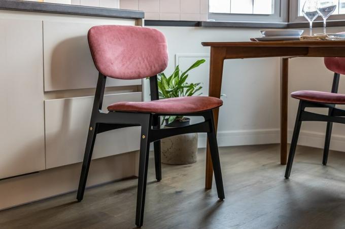 Rymma matbordet bjuda fyra stolar tillverkade av björkplywood belagd med en fuktbeständig emalj, med ryggar och säten klädda i rika rosa nyans.