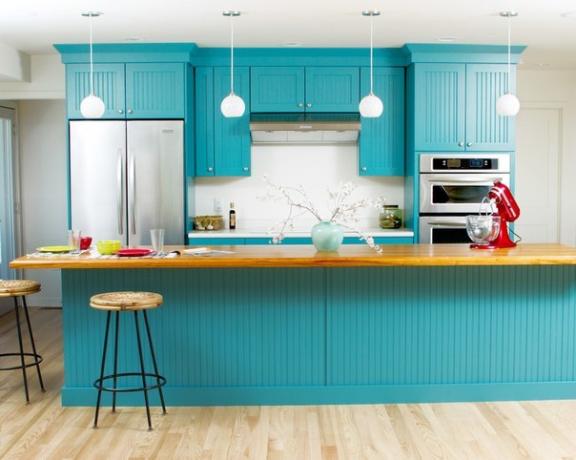 Köksuppsättning i turkosfärg kombinerat med ljusa väggar och golv