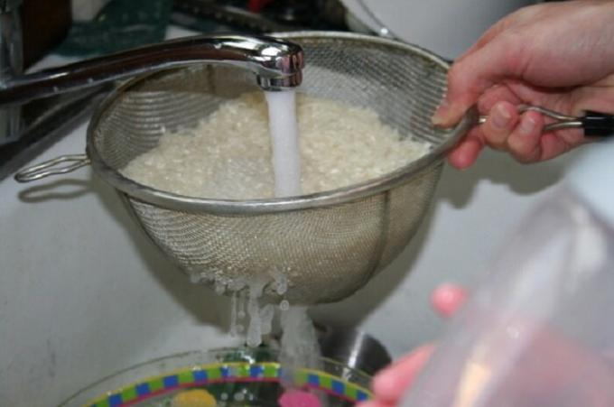 Tvätta riset i ett durkslag bekväm med rinnande vatten.