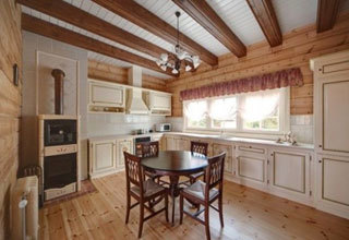 Provence-stil kök med trägolv och takbjälkar.