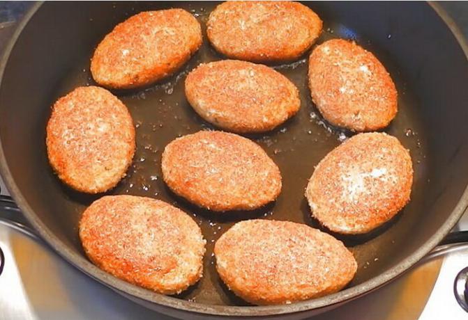 Stekt fisk kakor i en kastrull med vegetabilisk olja.